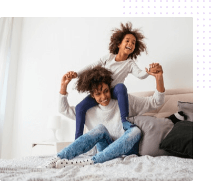 Mother and daughter playing on a bed