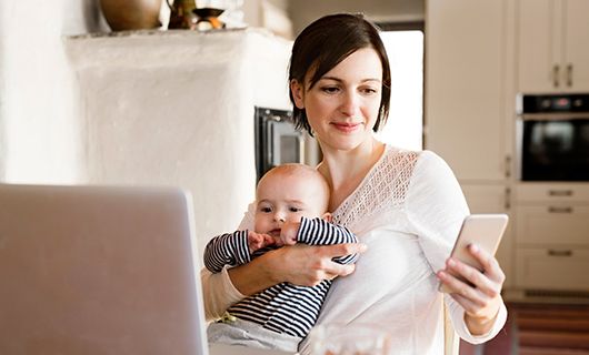 Woman on her phone holding a baby