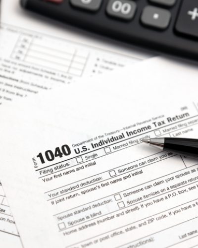 Tax form 1040 with eyeglasses and pen