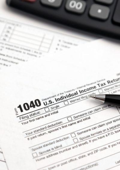Tax form 1040 with eyeglasses and pen