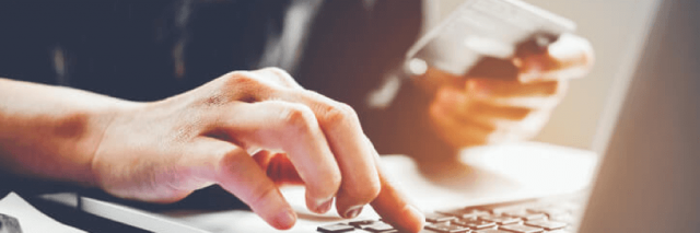 Man typing credit card information on computer