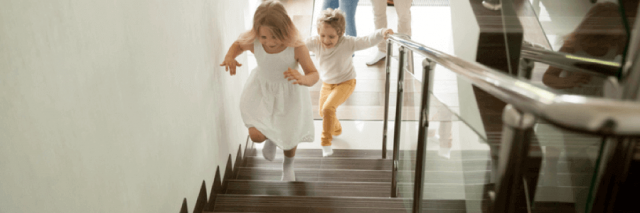 Kids running up stairs in home