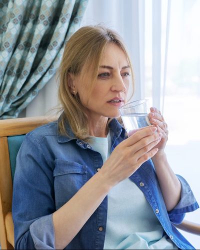 Sick woman holding a glass of water