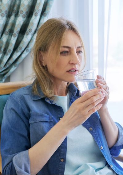 Sick woman holding a glass of water