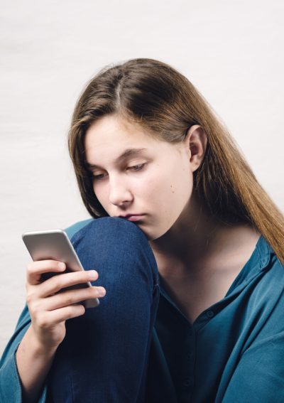 Young girl looking sad at phone