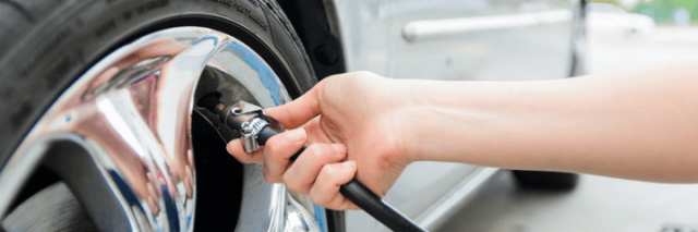 Boy putting air in car tires