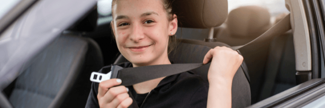 Teenage girl buckling her seatbelt