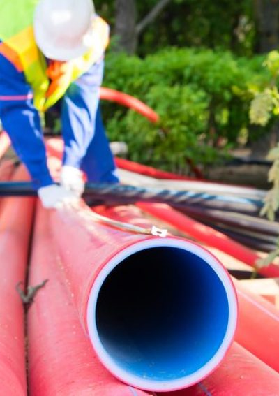 Construction worker handling red pipes