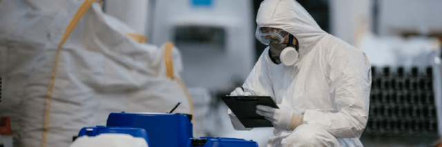 Factory worker wearing gas mask and radioactive protection suit