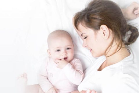 mother laying in bed next to her child