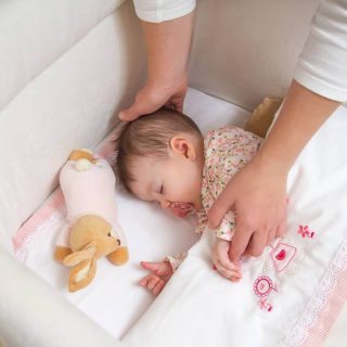 Baby sleeping in crib with bumpers