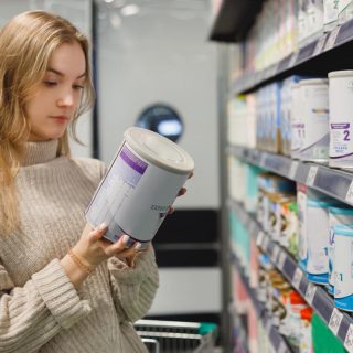 Woman looks at baby formula ingredients