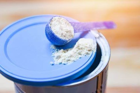 Baby formula scoop on lid of container