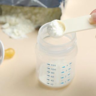 Baby bottle with scoop of formula