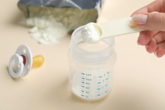 Baby bottle with scoop of formula