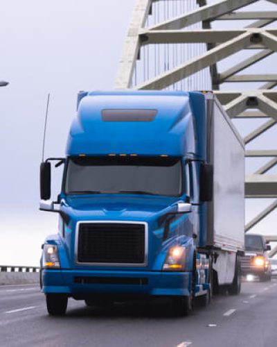 Blue truck driving over bridge