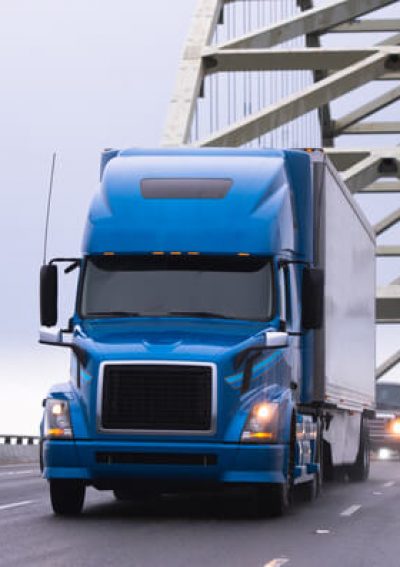 Blue truck driving over bridge