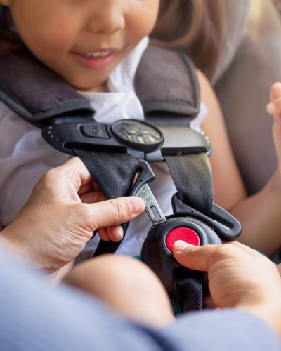 Child being strapped into car seat