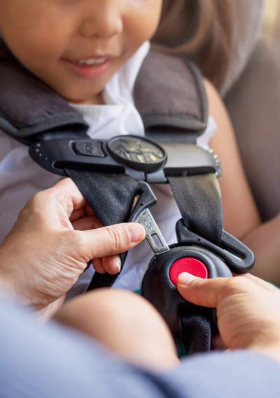 Child being strapped into car seat