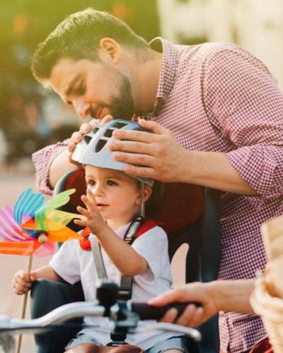 Father putting helmet on his son
