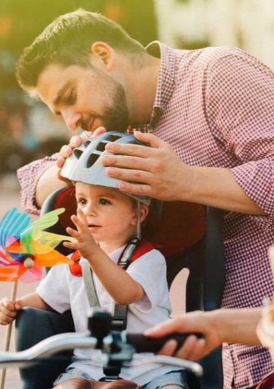 Father putting helmet on his son