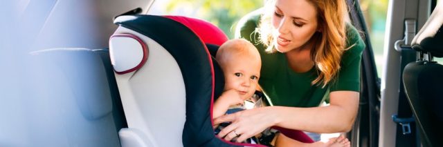 Mom adjusting child car seat
