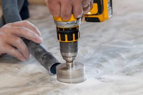 Man using circular drill to cut countertop