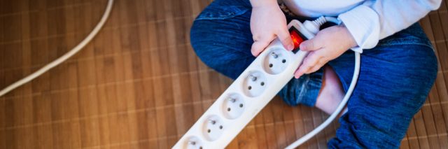 Baby playing with a power strip