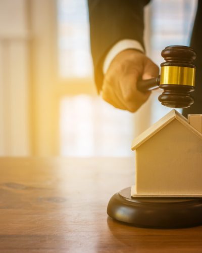 judge placing gavel over wooden house