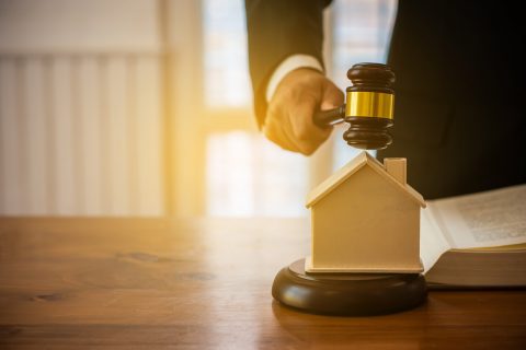 judge placing gavel over wooden house
