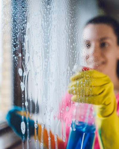 Young woman washing window