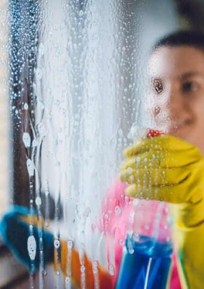 Young woman washing window