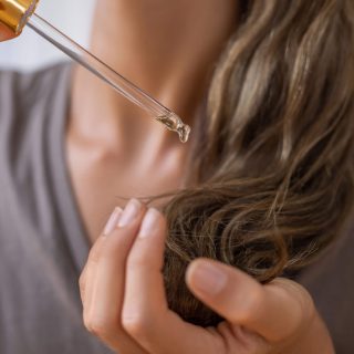 Hair care product drops being applied to hair