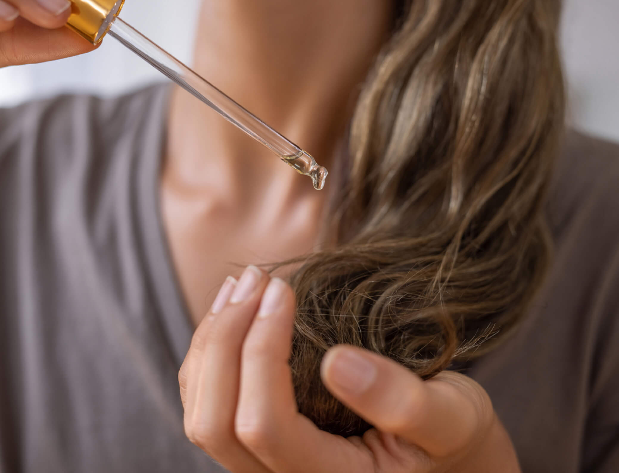 Hair care product drops being applied to hair