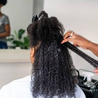 Woman having hair straightened in salon