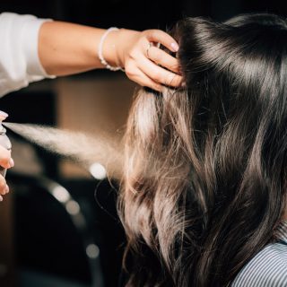 Hairdresser using aerosol spray can