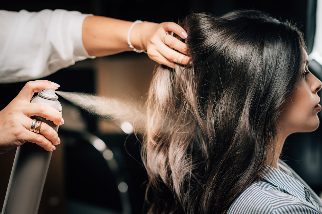 Hairdresser using aerosol spray can