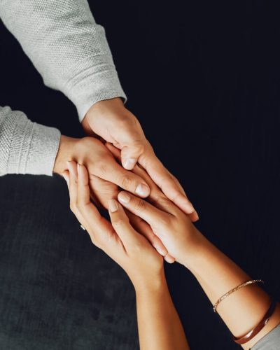 Two pairs of hands gently holding each other, symbolizing compassion, support, and trust.
