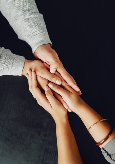 Two pairs of hands gently holding each other, symbolizing compassion, support, and trust.