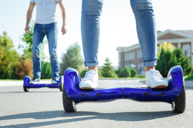 Two adults riding hoverboards.