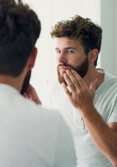 Man checks his face in the mirror