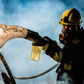 Firefighter spraying foam from hose