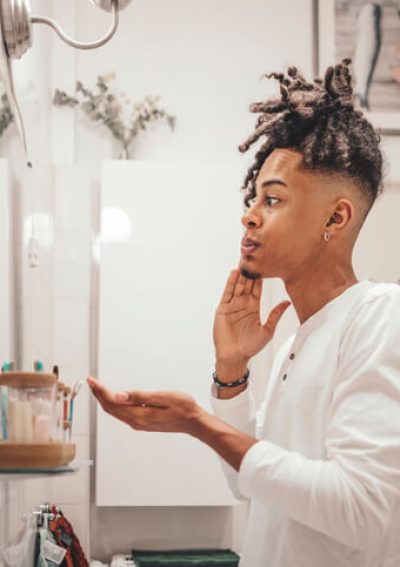 Man looking at his face in mirror