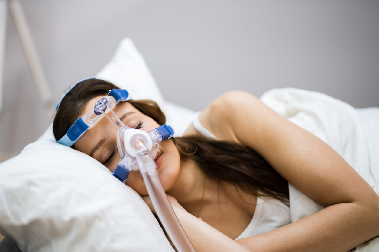 Woman sleeping with a CPAP mask on