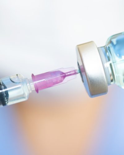 doctor's hand holds a syringe