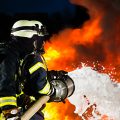 Firemen extinguishing a large blaze with foam