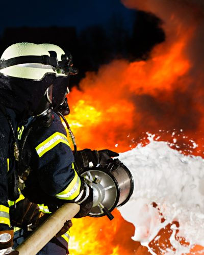 Firemen extinguishing a large blaze with foam