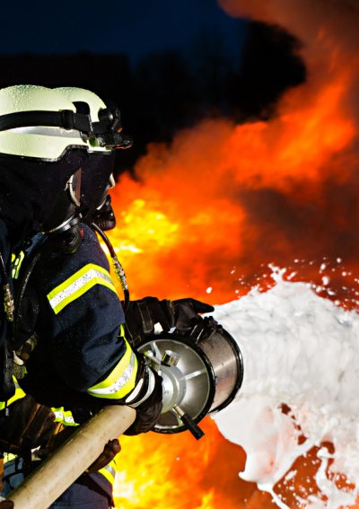 Firemen extinguishing a large blaze with foam