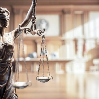 The scales of justice with a courtroom in the background