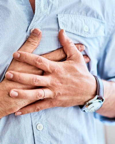 Man gripping chest in pain